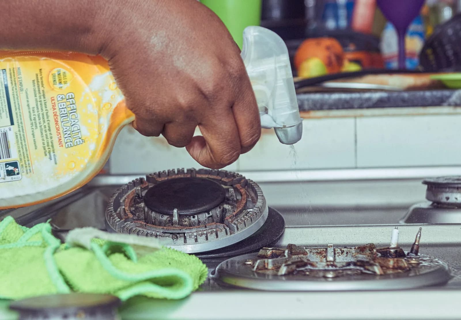Degreaser being sprayed onto a heavily soiled gas hob