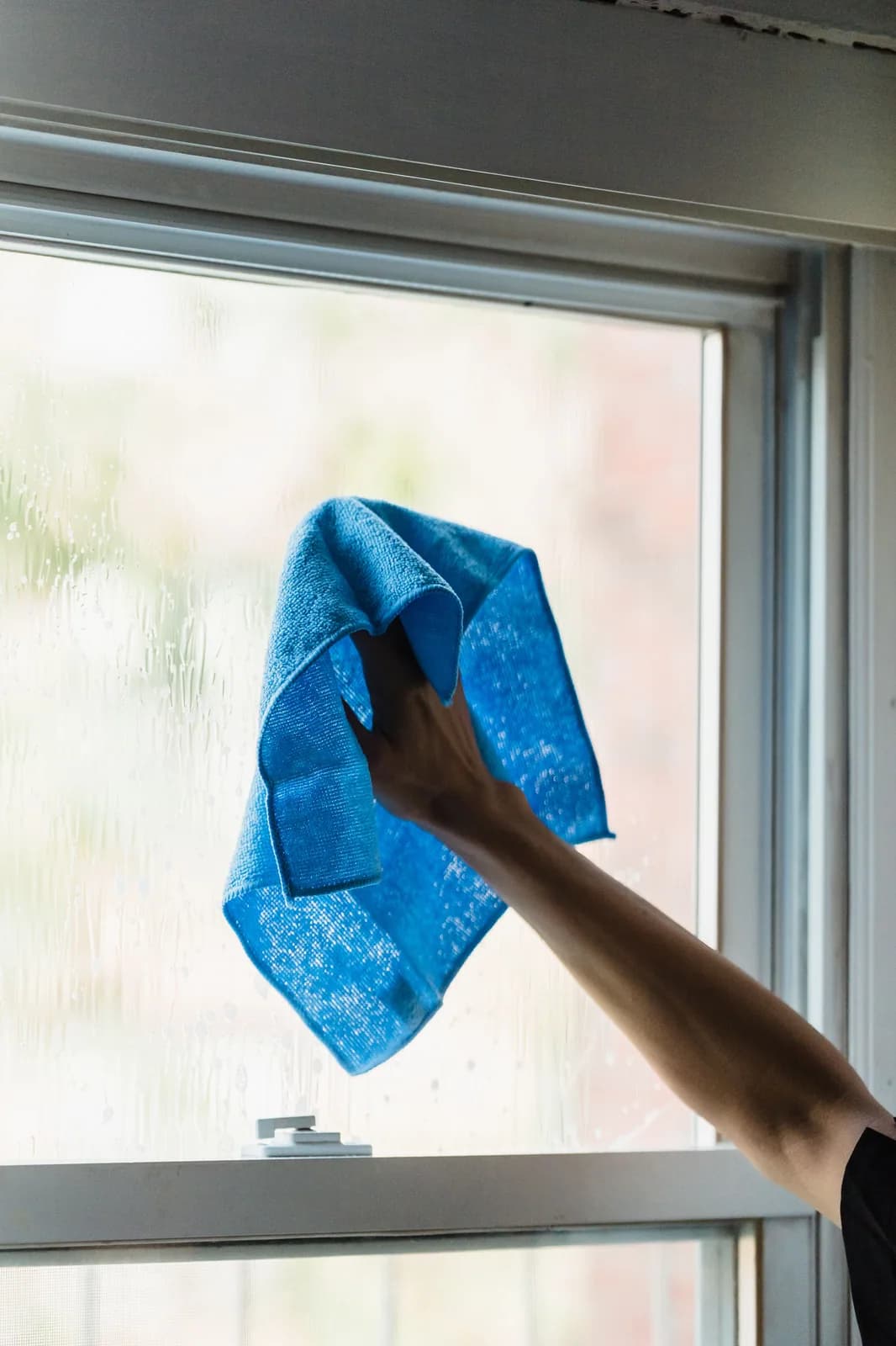 A cloth clearing a run of grime from a window pane